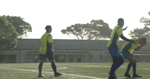 Soccer Players in Yellow Jerseys Celebrating Victory on Sunny Day