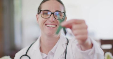 Smiling Female Doctor Showing Green Awareness Ribbon