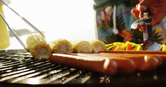 Midsection of caucasian man grilling vegetables on barbecue in the sun at beach, copy space. Food, summer, lifestyle and vacations, unaltered.