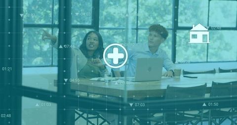 Professional team collaborating over analytics dashboard in modern glass conference room