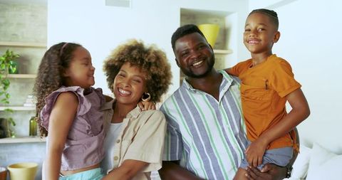 Joyful african american family bonding at home in stylish living room