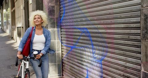 Young Woman Enjoying Urban Lifestyle with Bicycle and Coffee