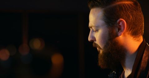 Guitarist performing passionately in dimly lit studio