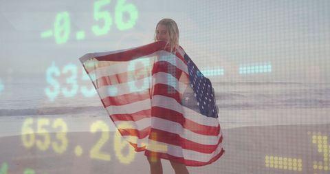Woman holding american flag on beach with financial data overlay