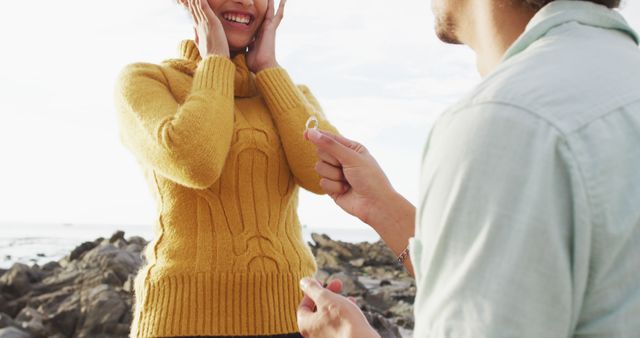 Man proposing to woman on beach makes great, emotional image for use in engagement announcements, relationship and romance-themed advertisings, and promotional materials for jewelry or wedding-related services.