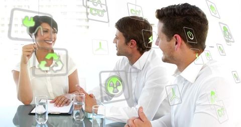 Business team discussing sustainable energy with AR green icons and digital overlays