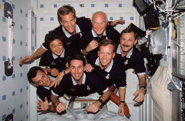STS095-328-031 (29 Oct.-7 Nov. 1998) --- With their feet anchored in the hatchway, the seven STS-95 crew members pose for their traditional in-flight crew portrait. Astronaut Curtis L. Brown Jr., commander, appears at right center in the pyramid.  Others, clockwise from there, are Steven W. Lindsey, pilot; Stephen K. Robinson, mission specialist; Pedro Duque, mission specialist representing the European Space Agency (ESA); payload specialist Chiaki Naito-Mukai, who represents Japan's National Space Development Agency (NASDA); Scott E. Parazynski, mission specialist; and United States Senator John H. Glenn Jr. (D.-Ohio), payload specialist.