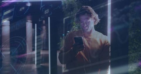 Man Engaged with Technology on Neon-Lit Urban Walkway