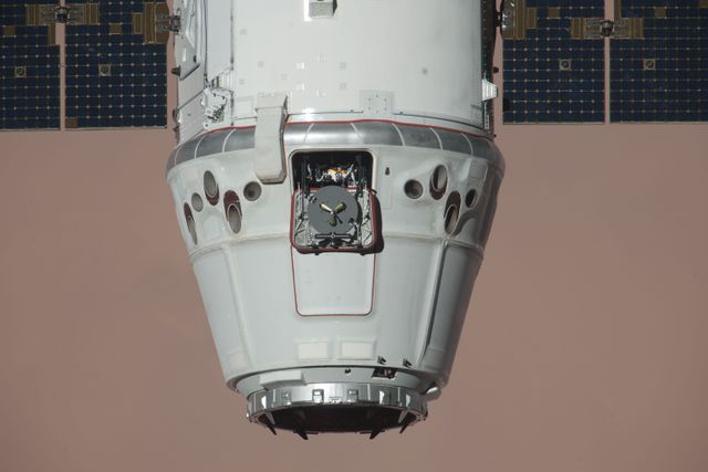 SpaceX Dragon cargo spacecraft nearing the International Space Station for its historic first docking on May 25, 2012. Captured and berthed by astronauts using the Canadarm2 robotic arm, this pioneering event showcases international collaboration in space exploration. Ideal for articles on space technology, historical space missions, or scientific advancements.