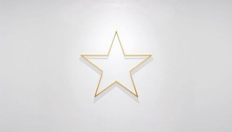 Minimal Gold Wireframe Star Sculpture on White Wall Casting Soft Warm Shadows