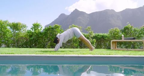 Woman Practicing Downward Dog Pose Outdoors Poolsid