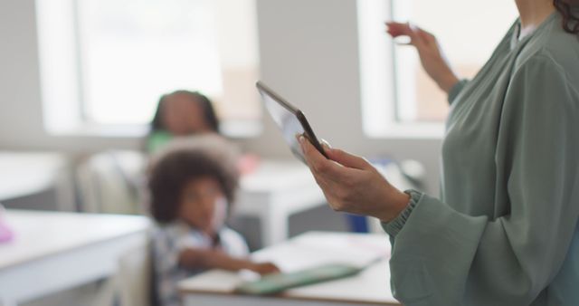 Teacher using tablet with students in classroom - Download Free Stock Images Pikwizard.com