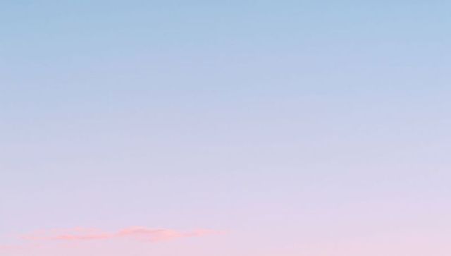 Serene minimal pastel sunrise sky with single pink cloud and expansive copy space