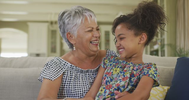 Grandmother and Granddaughter Laughing Together on Couch - Download Free Stock Images Pikwizard.com