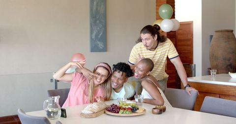 Diverse Friends Sharing Laughter and a Meal While Taking Selfie