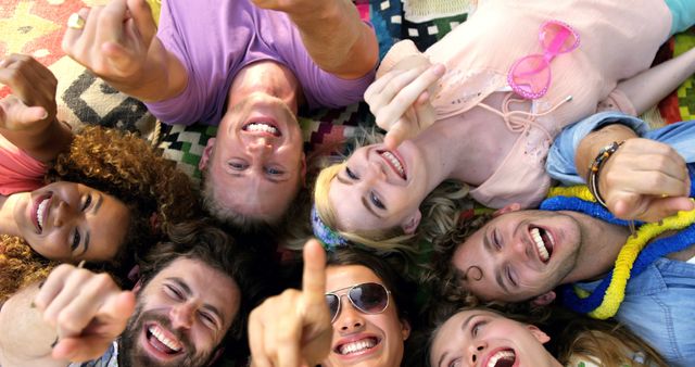 Cheerful Friends Lying On Picnic Blanket, Smiling and Pointing at Camera - Download Free Stock Images Pikwizard.com