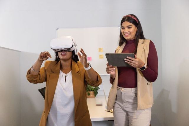 Diverse female coworkers testing vr headset for team collaboration and digital innovation