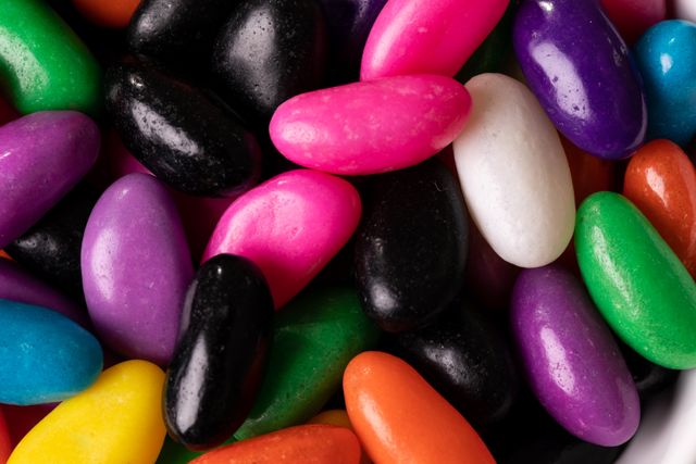 This image showcases a close-up view of a pile of colorful candies, making it perfect for use in advertisements, packaging designs, or articles related to sweets, snacks, and unhealthy eating habits. The vibrant colors and variety of candies can attract attention and add a playful, cheerful element to any project.