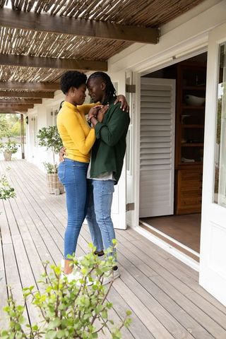 Romantic African American Couple Hugging on Cozy Wooden Deck
