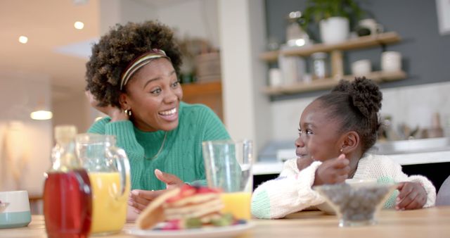 Mother and daughter enjoying breakfast together in cozy home kitchen - Download Free Stock Images Pikwizard.com