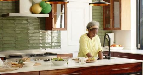 Senior Woman Enjoying Kitchen Chores in Modern Home