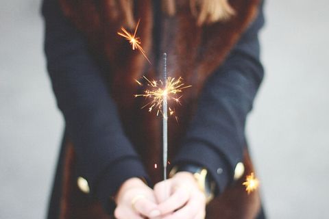 Person holding sparkler with festive focus