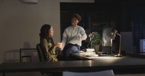 Diverse Colleagues Collaborating in Dimly Lit Office