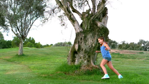 Girl Running Joyfully Around Large Tree