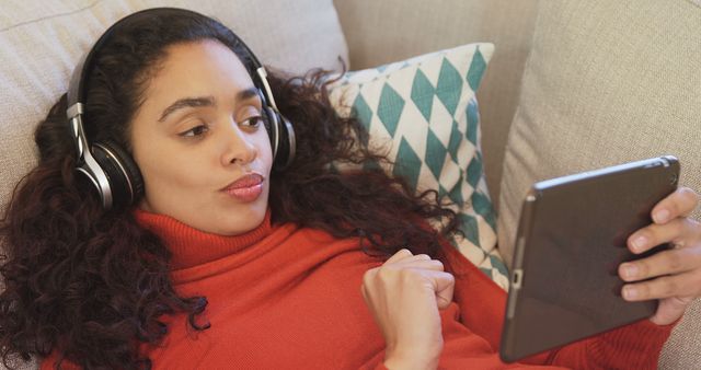 Woman Relaxing on Couch Watching Tablet and Listening with Headphones - Download Free Stock Images Pikwizard.com