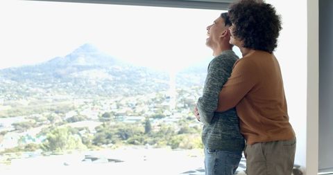 African american couple embracing by scenic valleyscape window