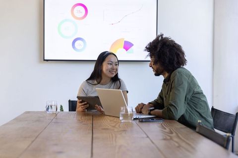Woman Using Tablet and Laptop Collaborating on Project