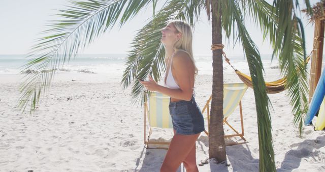 Smiling woman enjoying tropical beach with palm tree - Download Free Stock Images Pikwizard.com