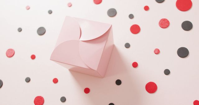 Overhead view of pink gift box on white background with red and black dots. Luxury treat, present, shopping, sale and retail concept digitally generated image.