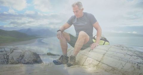 Mature Man Observing Ocean at Seaside with Outdoor Gear