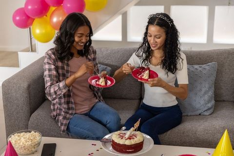 Young women enjoying cake at home celebration