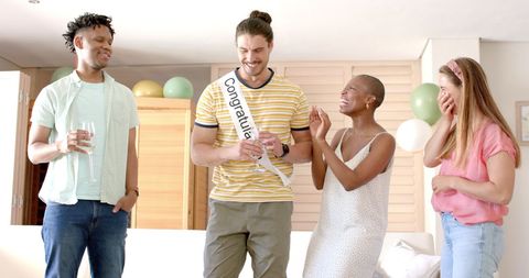 Four Friends Celebrating Joyful Moment Indoors With Drinks