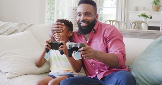 Father and Son Enjoying Video Game Together on Sofa at Home - Download Free Stock Images Pikwizard.com
