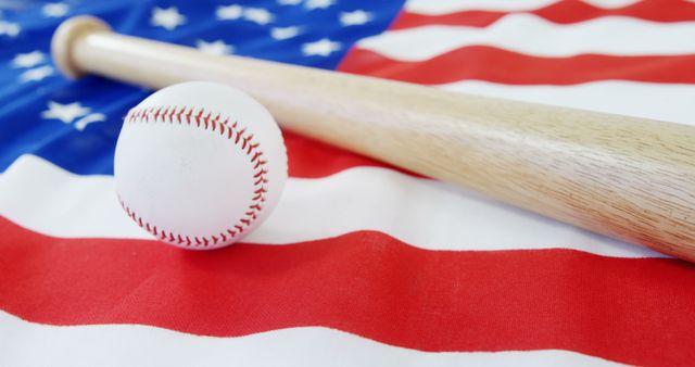 Baseball placed on American flag with wooden bat, representing America's favorite pastime. This image emphasizes patriotism and can be used for sporting events, Fourth of July celebrations, or promotional materials related to American sports culture.