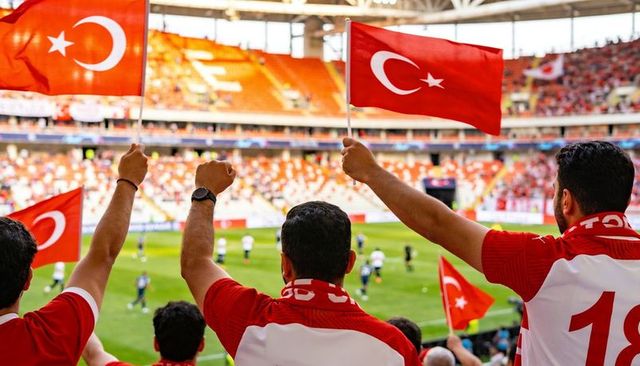 Fans waving turkish flags cheering national team in stadium during football match