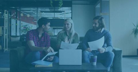 Diverse colleagues collaborating in office lounge discussing work