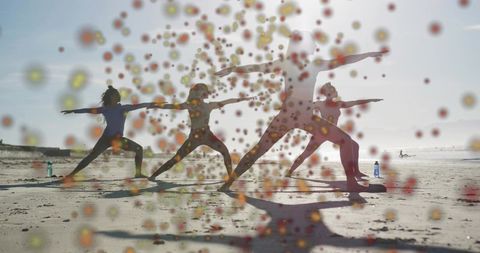 Sunlit beach yoga class practicing warrior ii poses, group silhouettes with bokeh overlay