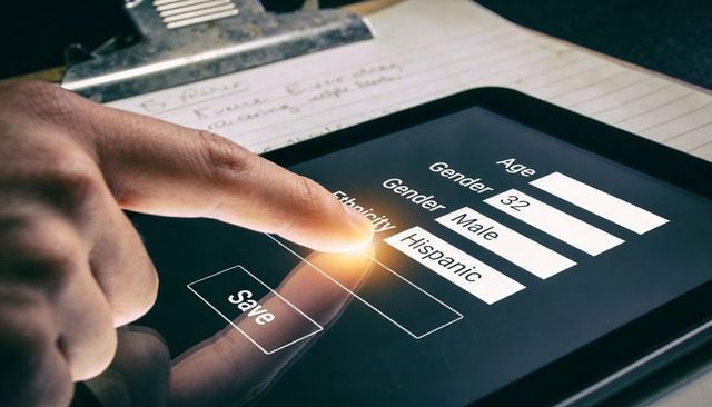 Touchscreen data entry finger pressing save on tablet demographic form closeup hispanic