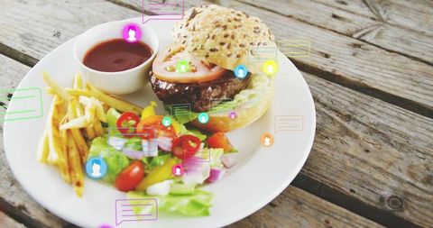 Gourmet burger with fries and salad on rustic wood table with colorful chat overlays