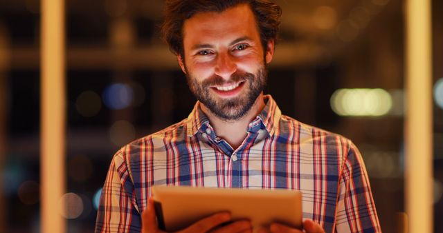 Smiling Young Man Using Digital Tablet in Modern Office at Night - Download Free Stock Images Pikwizard.com