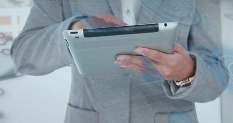 Holding Tablet with Digital Interface Overlay by Business Professional in Gray Blazer