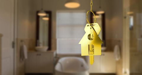 Golden Key in House Shape Dangling in Luxurious Bathroom Setting
