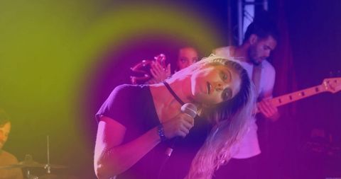 Singing Frontwoman Leaning with Microphone under Vibrant Stage Lights at Live Concert