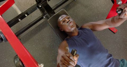 Focused Athlete Using Chest Press Machine for Intense Workout