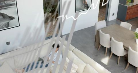 Remote worker typing on laptop on cream sectional sofa in bright open-plan home