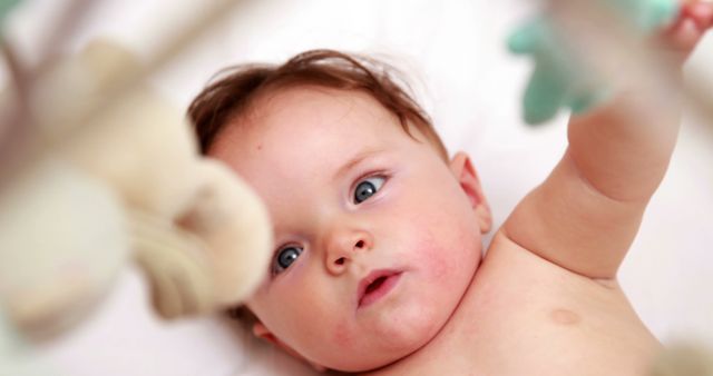 Adorable Baby Reaching for Toys in Crib - Download Free Stock Images Pikwizard.com